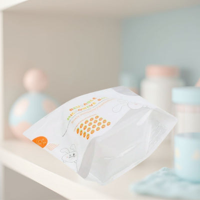Stérilisateur biberon sous forme de sac micro-ondes réutilisable, présenté dans une chambre de bébé aux tons pastel, idéal pour désinfecter rapidement les accessoires de puériculture.