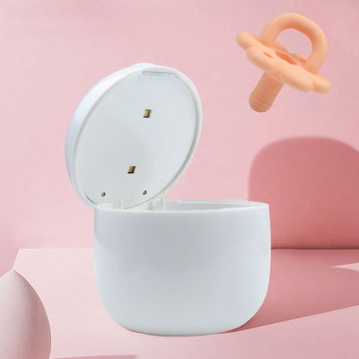 Main d’un parent insérant une tétine dans le stérilisateur tétine TétinePure™ pour une désinfection rapide et sans produit chimique.