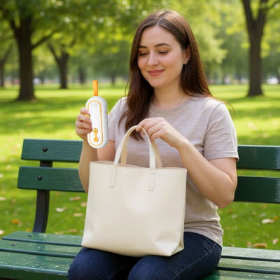 Tire-lait main libre portatif glissé dans un sac à main par une jeune maman en extérieur