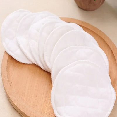 Coussinets d'allaitement lavables en coton écologique, posés sur un plateau en bois, parfaits pour une protection douce et durable.