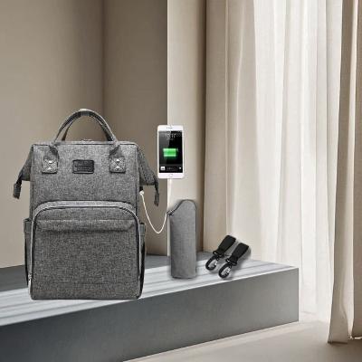 Le sac à dos à langer MumCare™ , doté de son port USB et de poches bien organisées, est posé dans un espace élégant. Conçu pour les parents modernes, il permet de rester connecté et organisé en toutes circonstances.