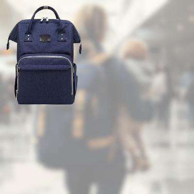 Sac à langer SerenityPack™ en bleu foncé, idéal pour les voyages en famille, avec un arrière-plan d'aéroport animé