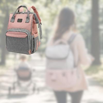 Sac à langer SerenityPack™ en couleur rose, mis en avant dans un parc avec une ambiance douce et apaisante pour les sorties en famille