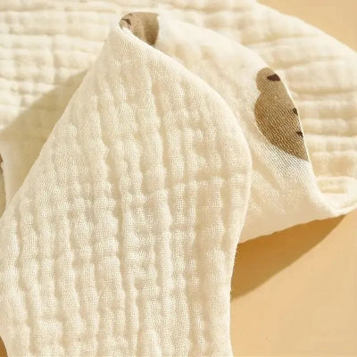 Zoom sur la texture coton bio épaisse et douce d’un bavoir bébé manche longue, tissu respirant et absorbant pour repas.