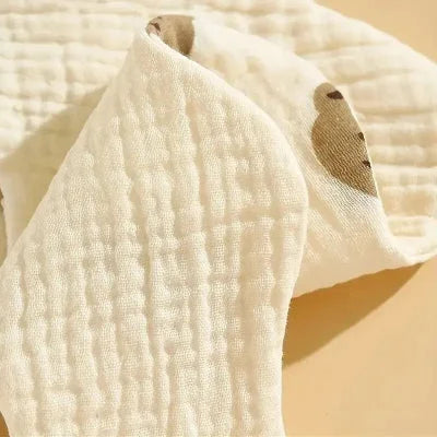 Zoom sur la texture coton bio épaisse et douce d’un bavoir bébé manche longue, tissu respirant et absorbant pour repas.