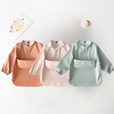 Lot de 3 bavoirs bébé manche longue imperméables BabyProtect™, coloris terracotta, rose poudré et vert sauge avec grande poche récupératrice.
