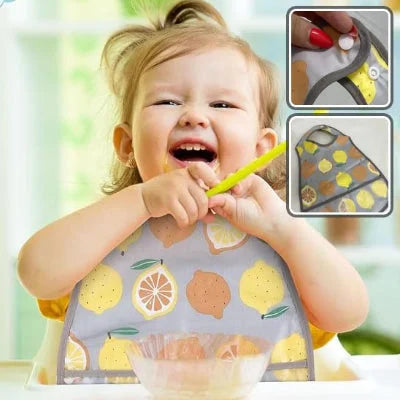 Enfant mange seul avec un bavoir bébé imperméable motif citron et fermeture réglable