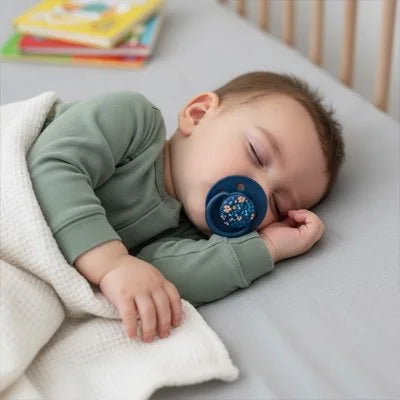 Bébé endormi paisiblement avec sucette bleue en silicone, sommeil réparateur et serein