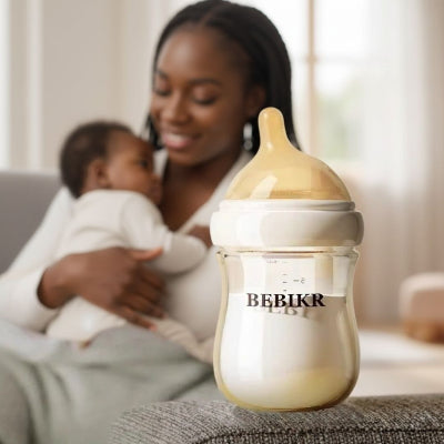 Maman donnant le biberon allaitement mixte en verre à son bébé, illustrant une transition sein-biberon naturelle et confortable.
