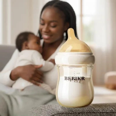 Maman donnant le biberon allaitement mixte en verre à son bébé, illustrant une transition sein-biberon naturelle et confortable.
