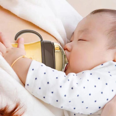  Bébé tétant un biberon en silicone imitant la forme et la sensation du sein maternel, facilitant la transition en douceur de l’allaitement au biberon.