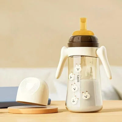 Biberon anti colique marron de 300 ml avec paille et poignées ergonomiques.