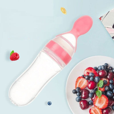 Biberon cuillère rose avec purée de fruits, idéal pour l’alimentation des bébés en toute simplicité.