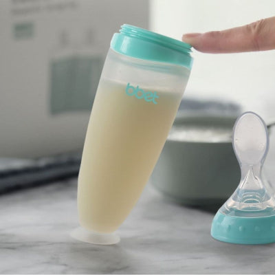 Biberon cuillère bleu avec base ventouse antidérapante pour plus de sécurité pendant les repas de bébé.