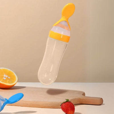 Biberon cuillère jaune avec graduation, facilitant le dosage précis des repas pour bébé.