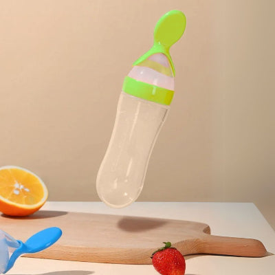 Biberon cuillère vert avec échelle de mesure pour une alimentation équilibrée.
