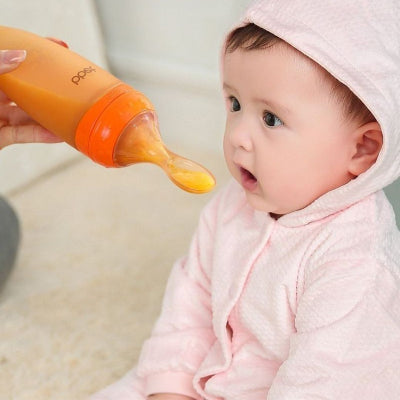 Biberon cuillère orange utilisé pour nourrir un bébé en toute douceur