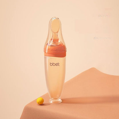 Biberon cuillère coloris orange pour bébé, livré avec trois types d'embouts pour une alimentation sereine à tout moment.