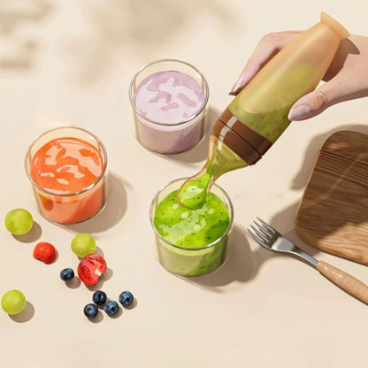 Biberon cuillère silicone servant du jus de kiwi et de carotte