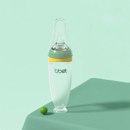 Biberon cuillère vert avec base stable et accessoires inclus pour un repas bébé sans tracas.