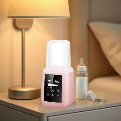 Chauffe biberon multifonction 6-en-1 rose sur une table de chevet, à côté d’un biberon de lait et d’une veilleuse allumée. Affichage LED à double température 45°C.

