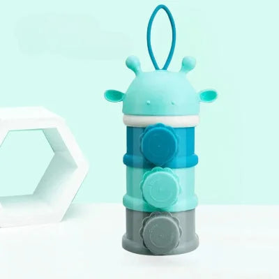 Boite doseuse lait en forme de girafe bleue avec trois compartiments et bouchons latéraux, parfaite pour stocker lait, snacks et accessoires bébé.


