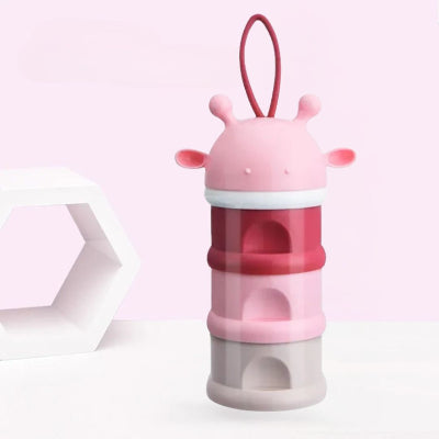 Boite doseuse lait LaitSnap™ rose en forme de girafe, design compact à trois compartiments pour stocker les doses de lait en sortie.

