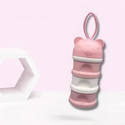  Boite doseuse lait rose pastel en forme d’ourson, composée de 3 compartiments hermétiques et poignée intégrée, parfaite pour préparer les biberons de bébé à l’avance.