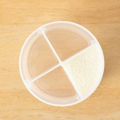 Vue intérieure de la boite doseuse lait MiniLait™ montrant les 4 compartiments séparés remplissables, pour une organisation parfaite des repas bébé.