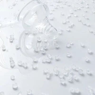 Bout de seins en silicone transparent entouré de granules alimentaires, illustrant la qualité médicale du matériau sans BPA.