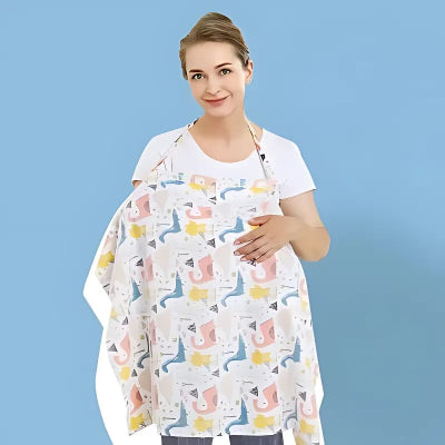 Cape d’allaitement colorée à motifs dinosaures portée par une maman souriante, assurant intimité et confort pendant l’allaitement, fond bleu uni.

