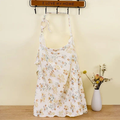 Cape d’allaitement Voilâme™ à motifs fleuris pastel style liberty, idéale pour un allaitement discret à la maison ou en balade.

