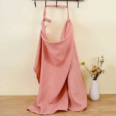 Cape d’allaitement Voilâme™ rose poudré unie, en mousseline douce et respirante, alliant style épuré et fonctionnalité.