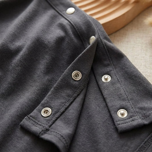 Gros plan boutons-pression argentés du poncho allaitement Solène™ gris — système d'ajustement breveté, finition soignée