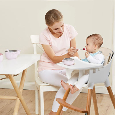 Chaise haute bébé en bois avec plateau repas amovible, harnais de sécurité et assise confortable, parfaite pour les repas en cuisine au design scandinave.
