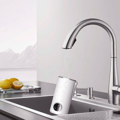 Chauffe biberon sans fil en cours de nettoyage sous l’eau, illustrant sa facilité d’entretien et sa résistance à une utilisation quotidienne.