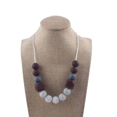 Collier d’allaitement aux tons bordeaux et gris, en perles texturées pour stimuler les sens et soulager bébé pendant les poussées dentaires