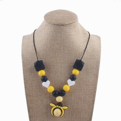 Collier d’allaitement noir et jaune avec pendentif abeille, perles contrastées et coeurs blancs, idéal pour stimuler la vue et soulager les gencives.
