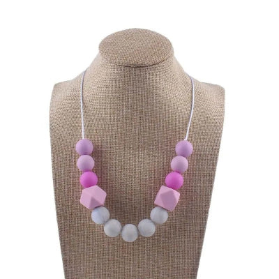 Collier d’allaitement dans les tons lavande et rose avec perles sensorielles, stimulant la motricité fine et apaisant bébé pendant l’allaitement