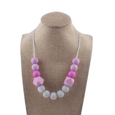 Collier d’allaitement dans les tons lavande et rose avec perles sensorielles, stimulant la motricité fine et apaisant bébé pendant l’allaitement
