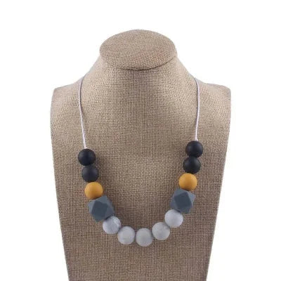Collier d’allaitement en silicone noir, moutarde et gris, idéal pour soulager les poussées dentaires et stimuler la motricité fine de bébé