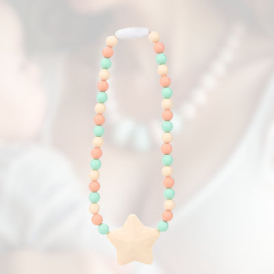 Collier d’allaitement pastel en silicone alimentaire avec étoile crème, idéal pour stimuler la motricité fine de bébé pendant l’allaitement ou le portage.

