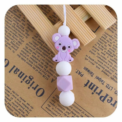 Collier d’allaitement violet en silicone alimentaire, orné d’un adorable koala, conçu pour éveiller bébé et soulager ses gencives sensibles.