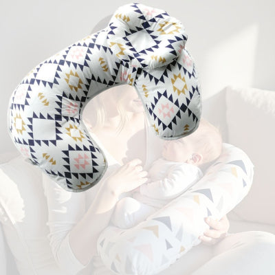 Maman en train d’allaiter son bébé avec le coussin d’allaitement motif aztèque chic, maintien parfait pour des tétées sereines.
