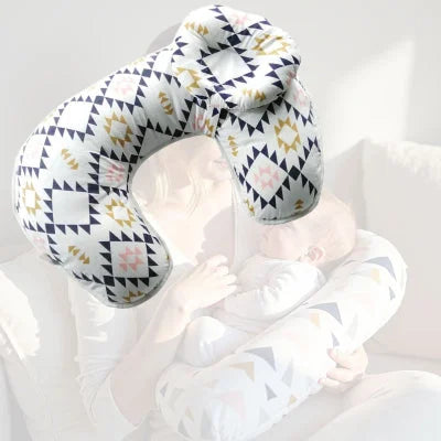 Maman en train d’allaiter son bébé avec le coussin d’allaitement motif aztèque chic, maintien parfait pour des tétées sereines.
