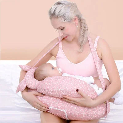 Maman allaitant son bébé avec le coussin d’allaitement rose, qui soutient parfaitement la tête de bébé et réduit les douleurs musculaires.
