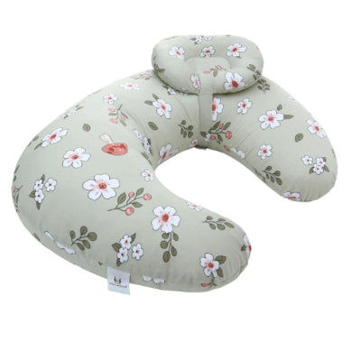 Coussin d’allaitement en tissu vert sauge à fleurs blanches, offrant un soutien ergonomique pour maman et bébé pendant l’allaitement et le repos post-partum.

