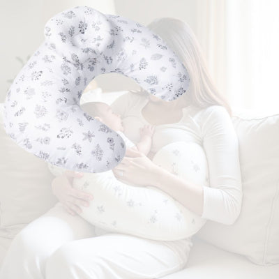 Jeune maman utilisant le coussin d’allaitement motif herbiers tendres pour nourrir son bébé, confort naturel et apaisant.