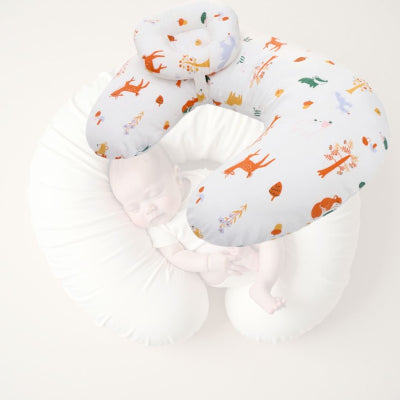 Bébé endormi dans un coussin d’allaitement croissant, illustrant la fonction de maintien et de sécurité du produit lors des moments de repos ou d’allaitement.


