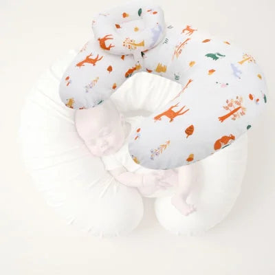 Bébé endormi dans un coussin d’allaitement croissant, illustrant la fonction de maintien et de sécurité du produit lors des moments de repos ou d’allaitement.


